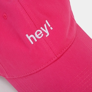 Close-up of hey! embroidery and cotton twill texture on bright pink baseball cap