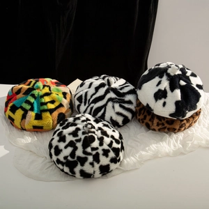 Detailed overhead view of plush faux fur berets featuring cow, zebra and leopard patterns