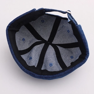Detail of blue denim docker hat showing reinforced internal seams and metal adjustment buckle