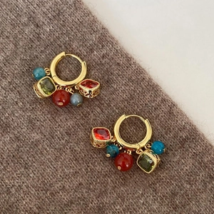 Detailed close-up of ethnic style gold hoop earrings with colorful zircon and beads