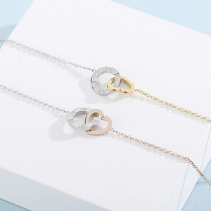 Detail of interlocking heart and diamond-set circle pendant on a sleek metal necklace