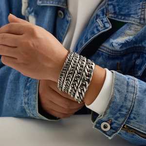 Dettaglio di bracciali a catena cubana argento su un modello uomo per uno stile hip-hop di tendenza