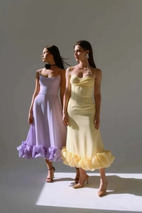 Artistic studio shot of elegant midi dresses with tiered ruffles and corset bodice