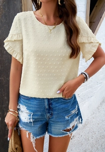 Detail of ruffle sleeve and textured polka dot fabric on a beige women top