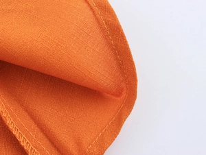 Détail du tissu orange avec couture de qualité sur le bord d'une robe de plage d'été