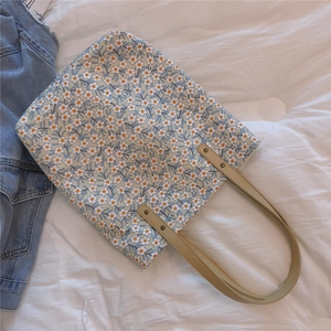 Détail du sac cabas floral avec motifs marguerites et poignées en cuir renforcées
