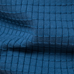 Macro d'un tissu tricoté bleu montrant le tissage texturé unique avec motif à carreaux