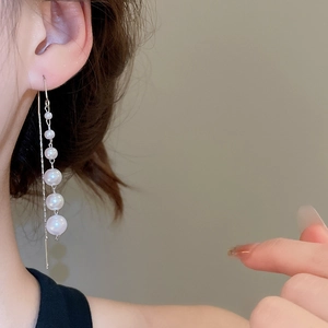 Elegant silver long ear threads with five gradient white pearls on model for party