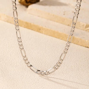 Elegant S925 sterling silver Figaro chain necklace for women on a textured stone slab