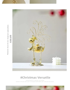 Golden iron reindeer Christmas figurine with spiral antlers on a white tabletop
