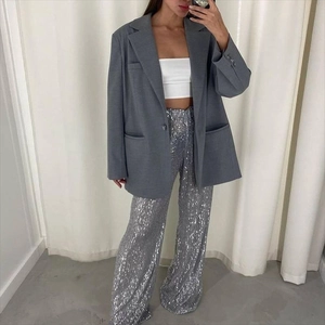 Detailed view of silver sequined straight-leg trousers with shimmering metallic texture