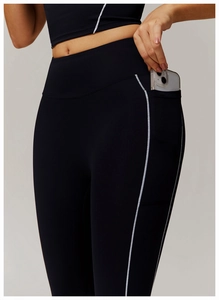 Detalle del bolsillo lateral de los leggings de yoga de cintura alta con puntos reflectantes