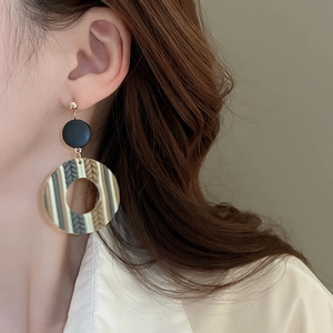 Close-up of Bohemian layered drop earrings with colorful textured rings on model