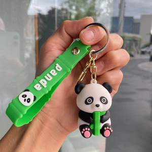 Close-up of cute 3D panda keychain with green wrist strap and bamboo holding detail