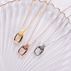 Three minimalist rectangular pendant necklaces in gold, rose gold and silver on a white tray