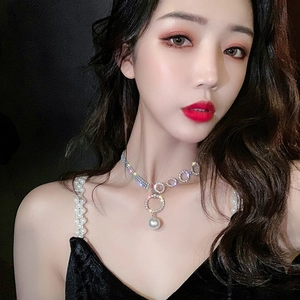 Close-up of sparkling geometric circles and pearl necklace on female model neck