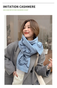 Detail showing soft blue imitation cashmere scarf with cute bear pattern and lettering