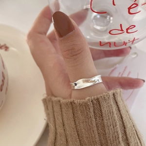 Close-up of minimalist wave-textured S925 sterling silver ring on a model's hand