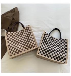 Detail of checkered canvas tote bags in brown and black with textured fabric finish