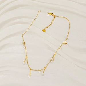 Gold stainless steel necklace with round zircon tassels on white satin background