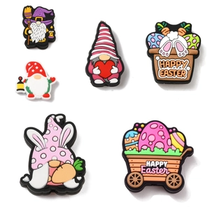 Close-up of Easter gnome shoe charms and colorful bunny egg accessories on white background