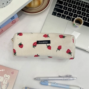 Corduroy pouch with strawberry pattern and metal zipper on an office desk