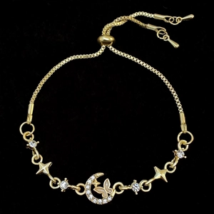 Detail of adjustable gold bracelet with moon star butterfly charms and white zircons