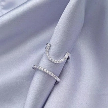 Primer plano de anillos de corazón de plata con piedras claras sobre raso morado