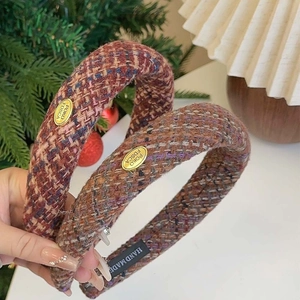Tweed headbands in brown and orange tones featuring elegant oval golden metal logo plaques