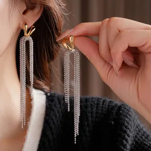 Elegant 18k gold plated tassel earrings with delicate silver bead chains on model