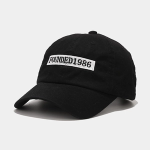 Detail of founded 1986 embroidery on black cotton twill baseball cap with curved brim