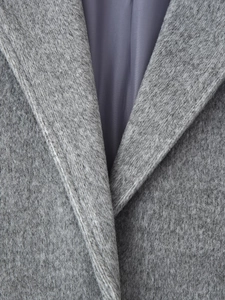 Close-up of premium grey wool coat lapel showing thick texture and smooth inner lining