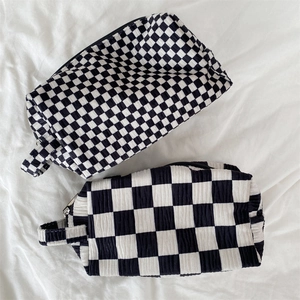 Macro view of checkered pattern makeup bags with black metal zipper and side handles