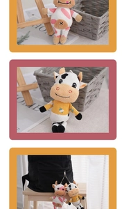 Dettaglio di portachiavi a forma di mucca in peluche con macchie rosa e maglione giallo