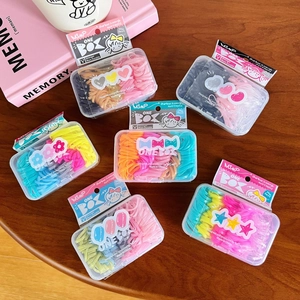 Set di 100 elastici per capelli colorati in scatola trasparente su un tavolo in legno