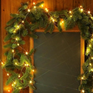 Artificial Christmas wreath with warm LED lights on a wooden wall for home decoration