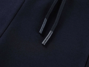 Close-up of deep blue drawstring tips and fine knit texture on high-waist yoga shorts
