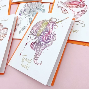Detailed macro view of a 3D laser-cut unicorn greeting card with a vibrant orange envelope