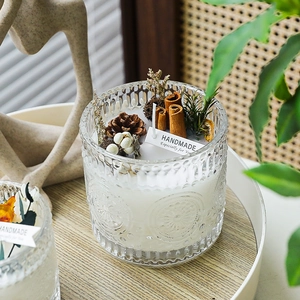 Nordic embossed glass storage jar with handmade candle and natural pinecone decorations