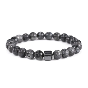 Macro detail of 8mm grey natural stone beads and textured metal cylinder on men's bracelet