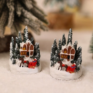 Lighted Christmas resin house with snowy village scene, trees, and red sleigh ornament