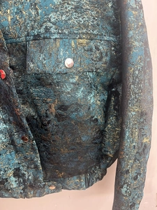 Detail of green sequin cotton jacket showing jacquard texture and silver button
