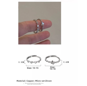 Macro detail of silver heart and butterfly ring showing size measurements and zircon inlay