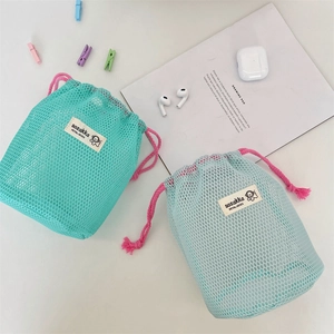 Detail of mesh drawstring storage bags in mint and light blue with breathable nylon texture