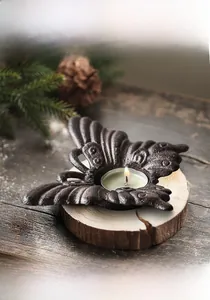 Détail d'un bougeoir papillon en fonte avec une texture rustique en bronze antique