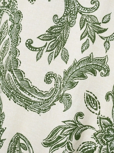 Macro detail of beige printed fabric with deep green paisley pattern and woven texture