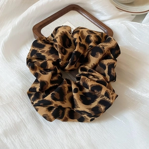 Detailopname van haarelastiekje met luipaardprint van zijdeachtige stof in luxe stijl