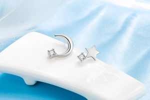 Macro shot of asymmetric star and moon earrings with sparkling zircon stones