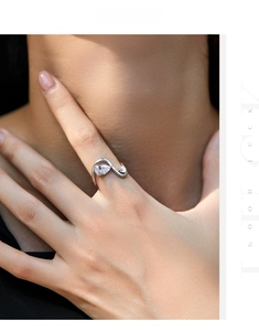 Detail of s925 silver ring featuring pear and round cut crystals on model's finger
