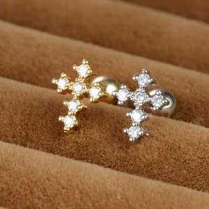 Macro detail of gold and silver cross ear studs with micro-pave cubic zirconia stones